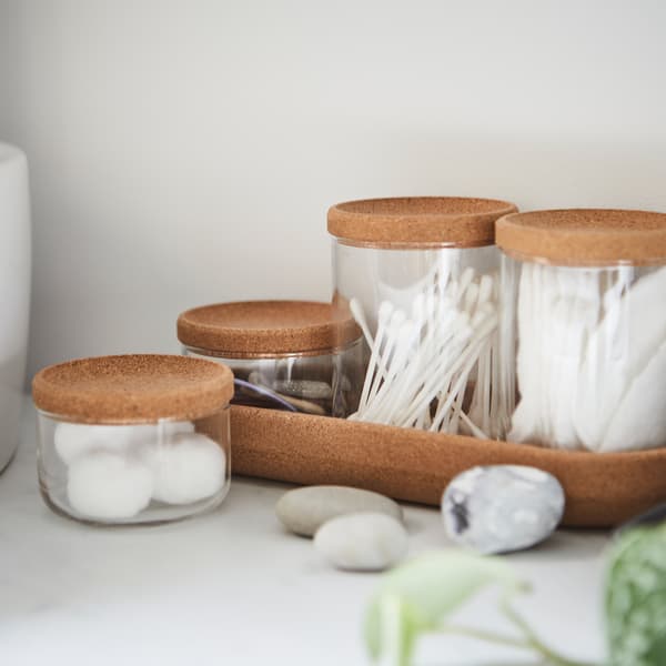 Four SAXBORGA glass jars in two different sizes with cork lids and a cork tray, holding cotton balls and Q-tips.