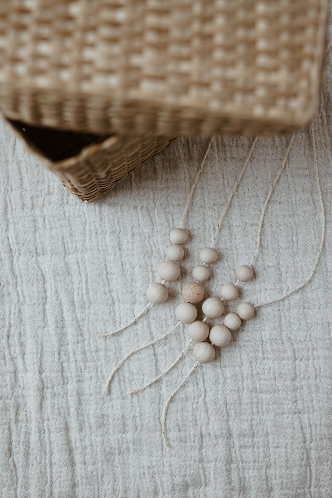 Four strings with beads lying on a white cloth
