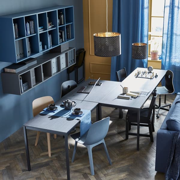 Four tables are arranged in a zigzag formation to accommodate different activities like chess, homework, and teatime.