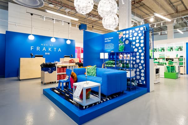 FRAKTA bag on display with blue sofa