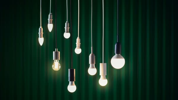 Framför en grön gardin händer nio SOLHETTA LED-ljuskällor från taket.