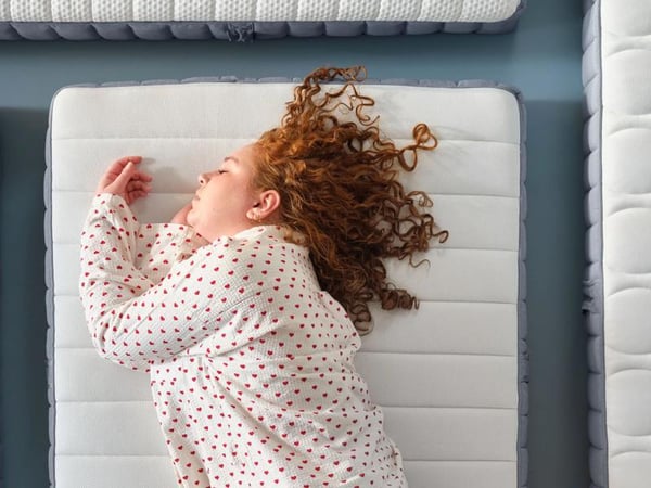 Frau liegt auf einer Matratze.