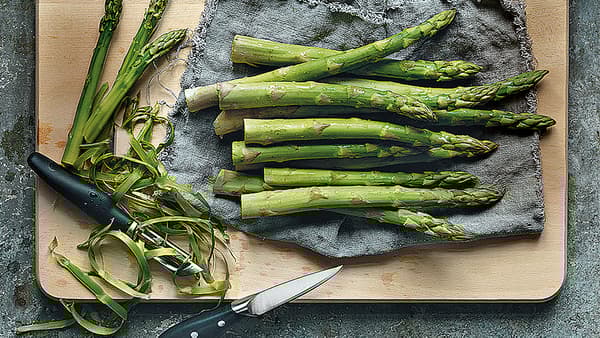 Frisch geschnittener, grüner Spargel auf einem Schneidebrett
