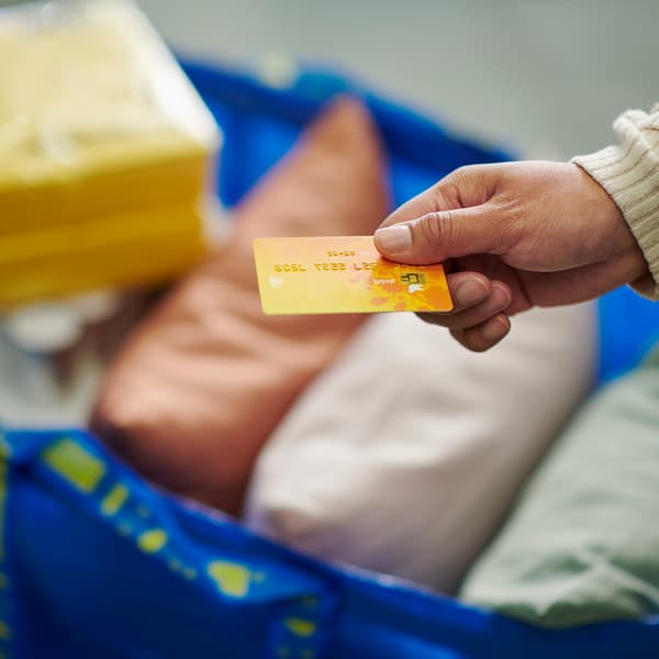 יד משיטה כרטיס אשראי מעל שקית FRKTA עם מוצרים