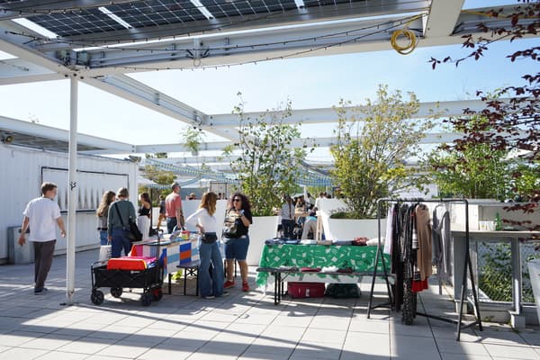 Fröhlicher IKEA-Flohmarkt unter freiem Himmel mit verschiedenen Ständen für gebrauchte IKEA-Möbel, Kleidung und Accessoires. Besucher schlendern entspannt durch das Angebot bei herrlichem Wetter