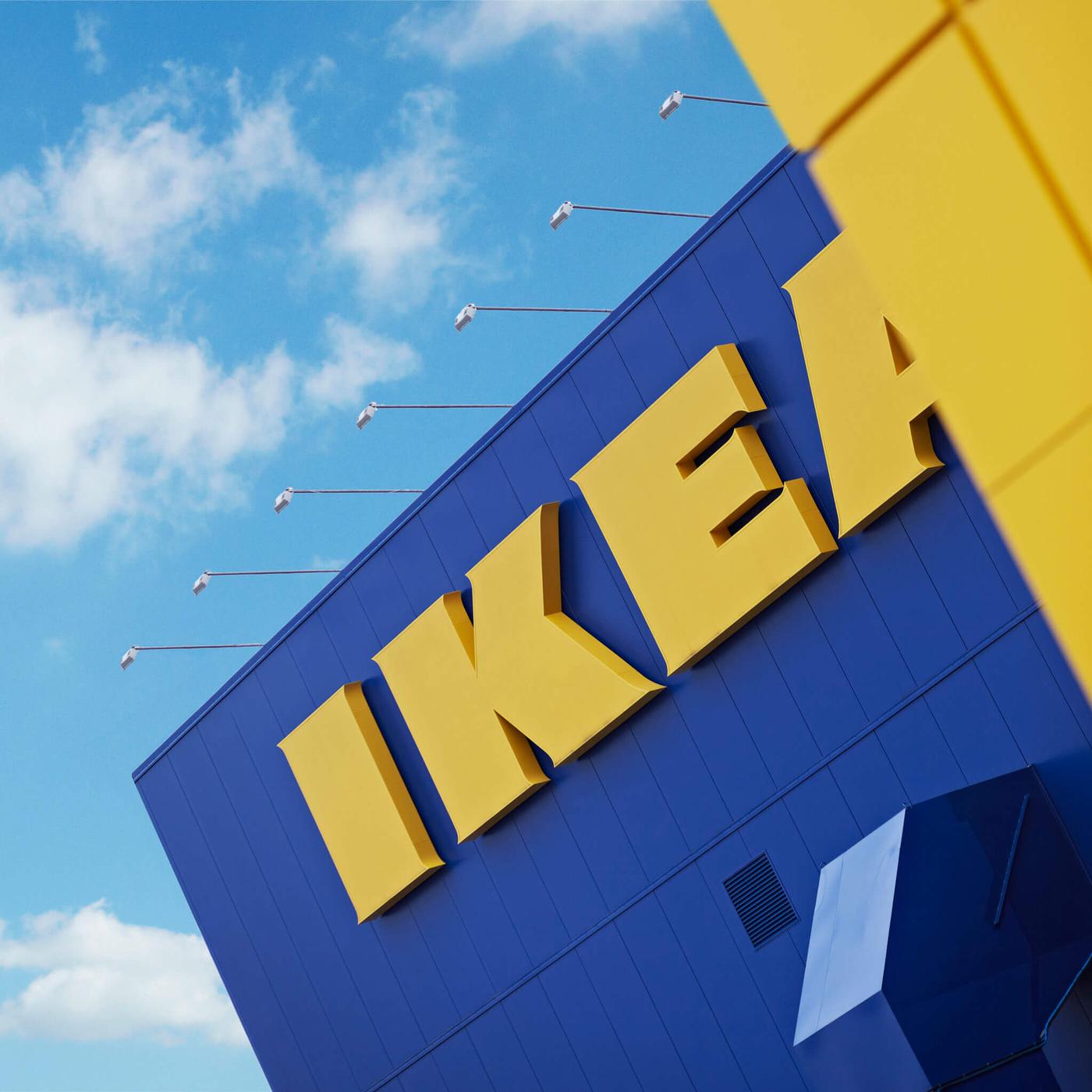Front of an IKEA store with blue skies and white couds above.