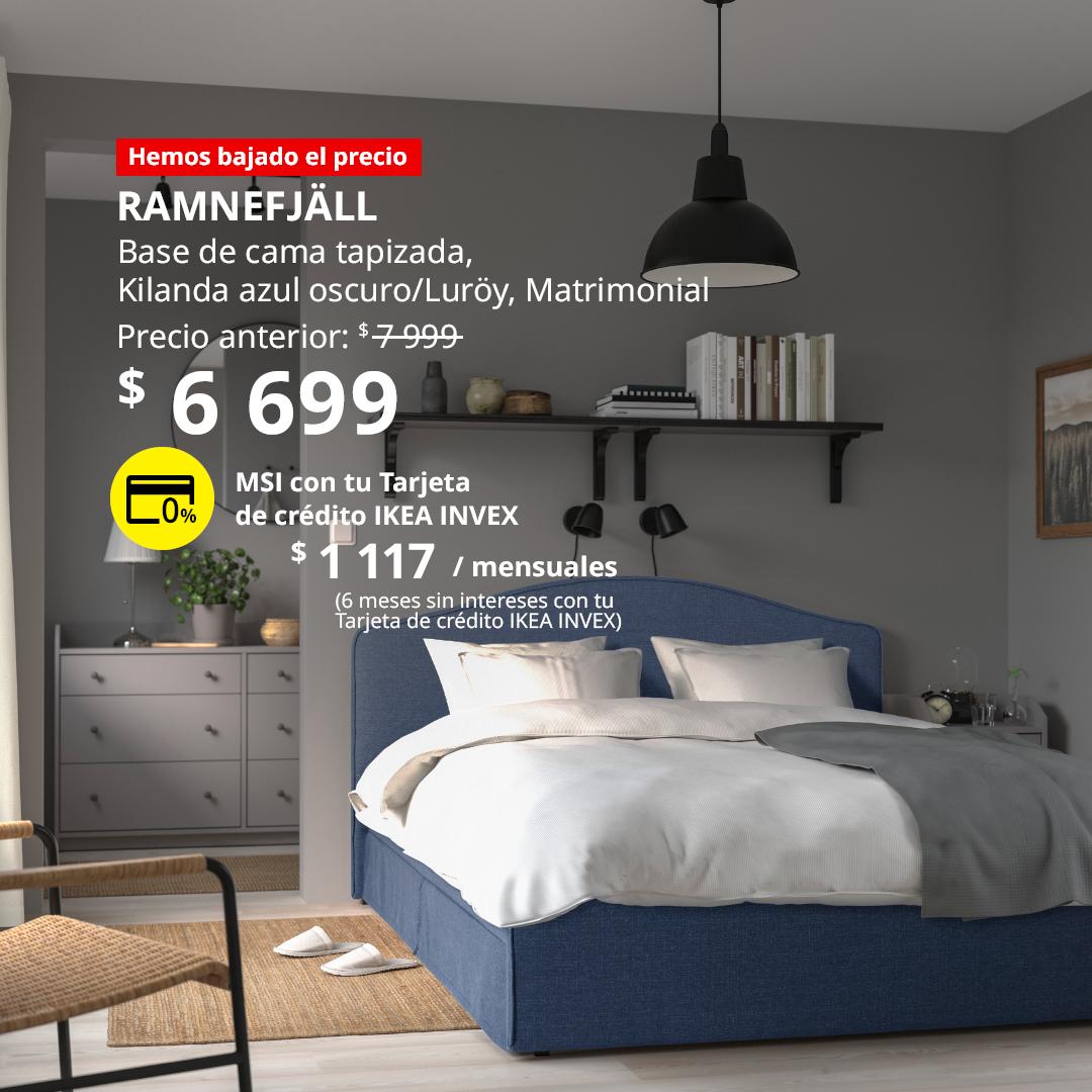 Funda para base de cama RAMNEFJÄLL en color azul oscuro Kilanda con base LURÖY, colocada en un dormitorio con ropa de cama blanca y detalles en tonos neutros.