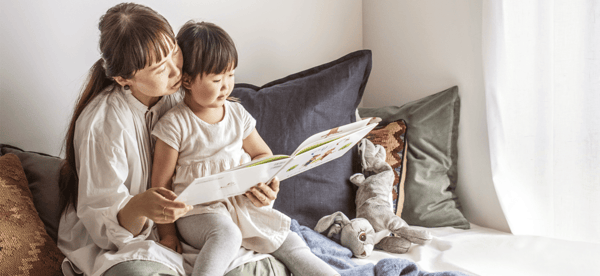 大人が子どもに読み聞かせをしている様子