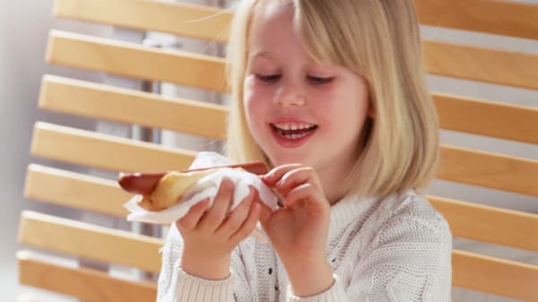 子供がホットドッグを食べている様子