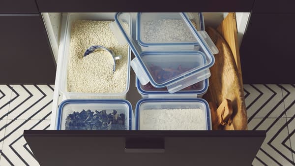 Gambar dekat laci yang terbuka dengan makanan dalam tin dan rempah teratur menggunakan pembahagi VARIERA.