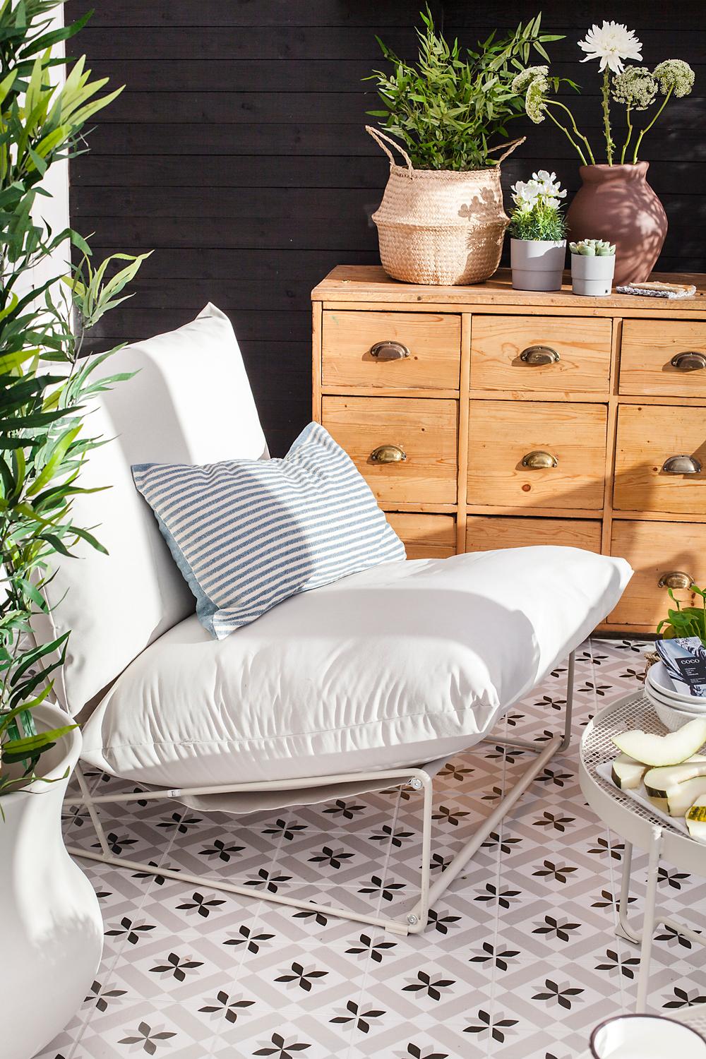 Gang med klær og klappstoler som henger på veggen, pluss en sykkel og en tavlevegg.