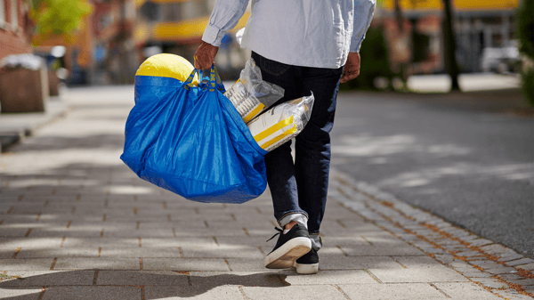 人が商品の入ったブルーバッグを持って歩いている様子