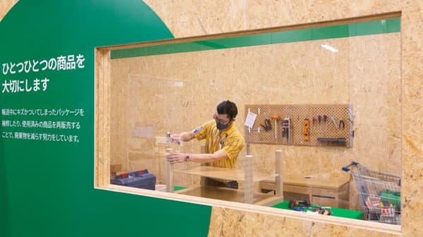 ガラス窓の向こうで家具のメンテナンスをしている
