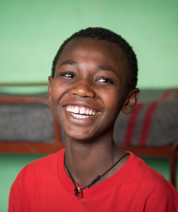 Garçon en T-shirt rouge, souriant.