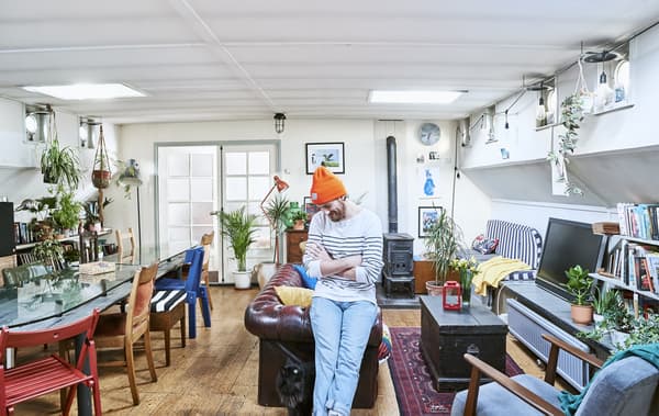 Gareth standing in his living room, with long dining table on one side and sofa area on the other.