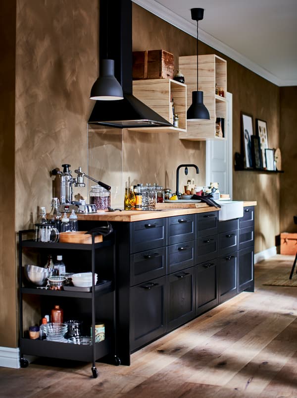 Gazdagon felszerelt konyhasarok kicsi, nyitott fali szekrényekkel, konyhai ventilátorral és sötét LERHYTTAN fiókfrontokkal.