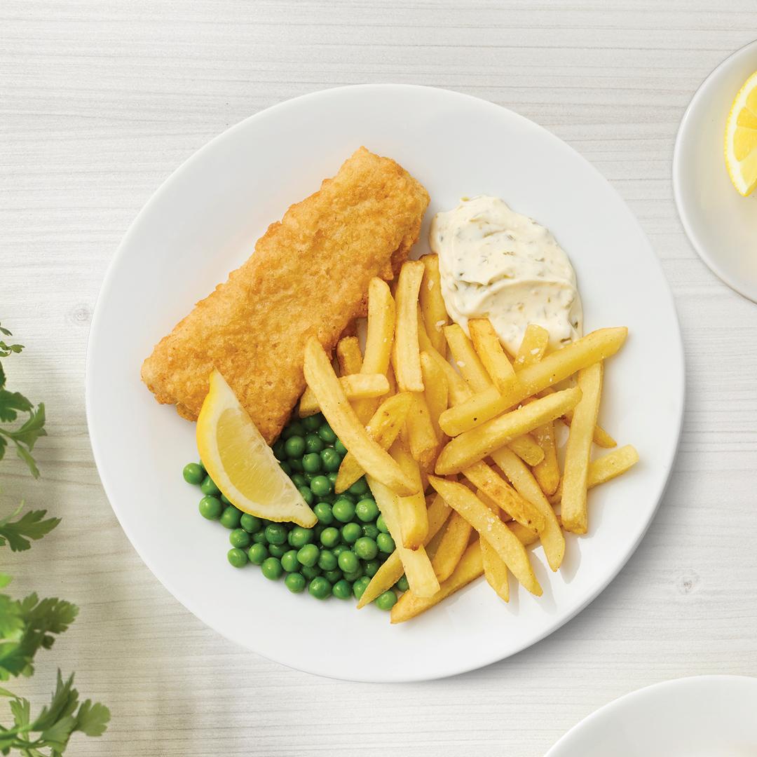 Gebackener Seelachs mit Erbsen, Pommes und Sauce auf einem weißen Teller präsentiert.