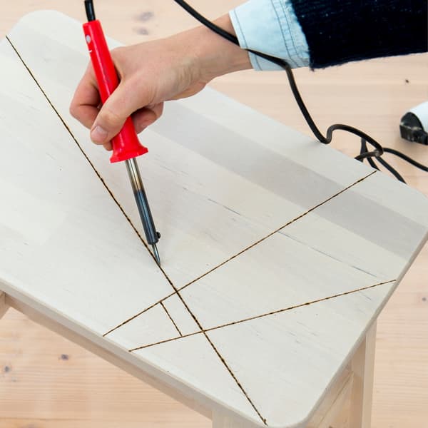 gebruik een pyrograaf om de lijnen in het hout te branden