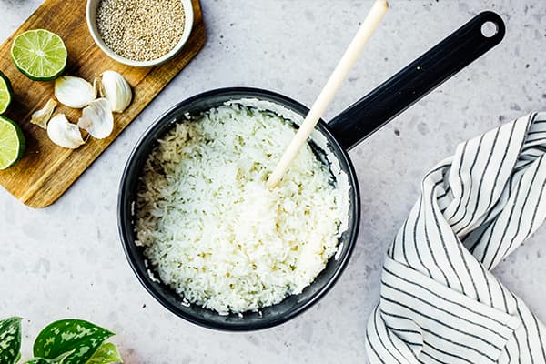 Gekochter Reis steht in einem Tpof auf einer Arbeitsplatte.