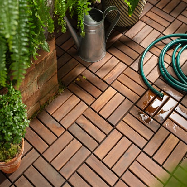 Geladak lantai kayu akasia padu, tumbuh-tumbuhan hijau di dalam pasu, penyiram yang dibuat daripada keluli tergalvani dan hos air berwarna hijau.