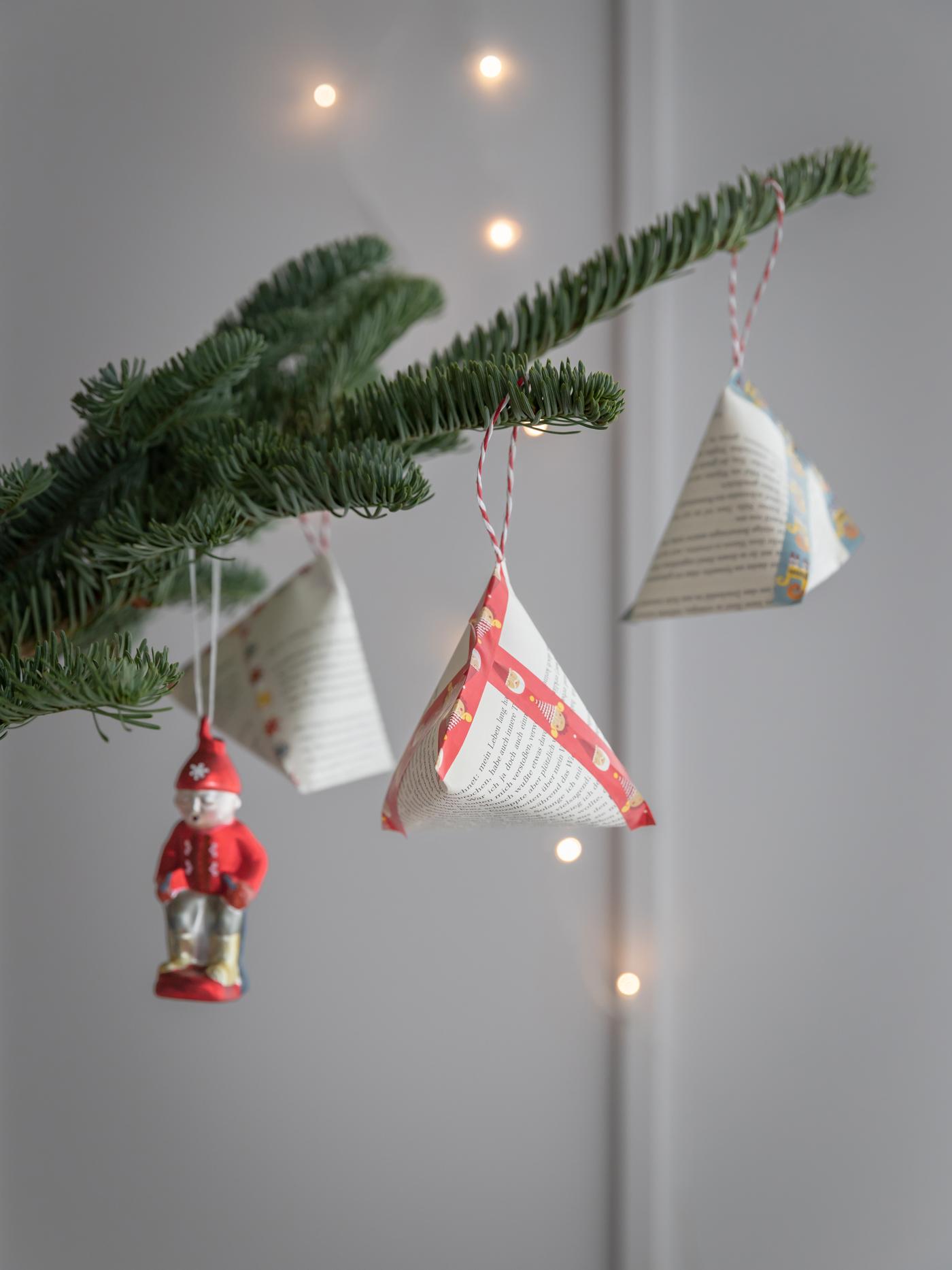 Geschenkverpackungen an einem Tannenzweig.