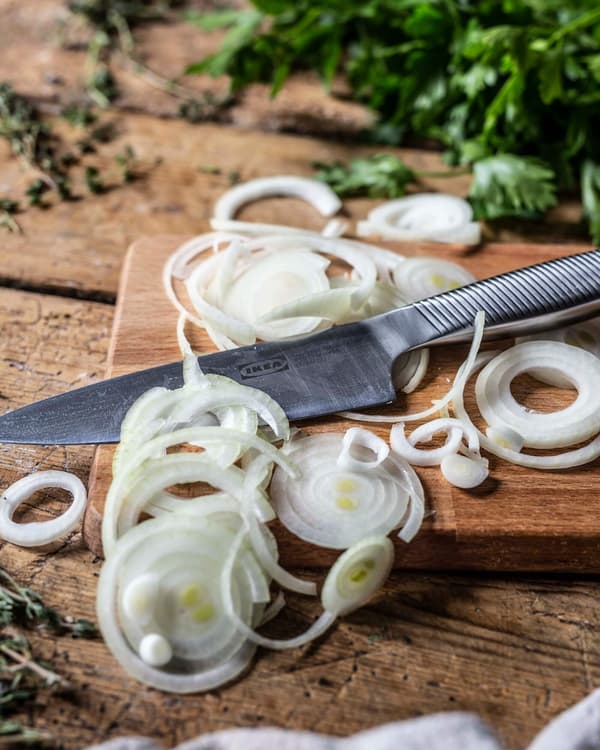 Geschnittene Zwiebelringe für eine Midsommar Quiche mit Pilzen.