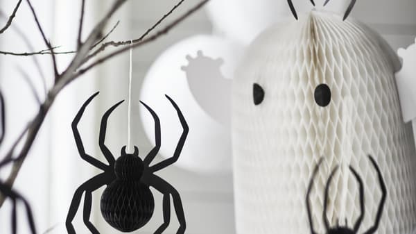 Ghost and spider Halloween decorations hanging from a tree
