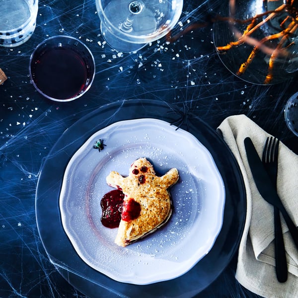 Ghost shaped cookie on white plate,