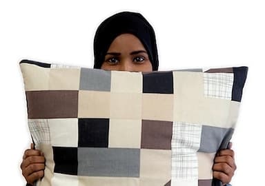 Giane from Ellas lo Bordan holding a cushion from the ÅTERSTÄLLA collection