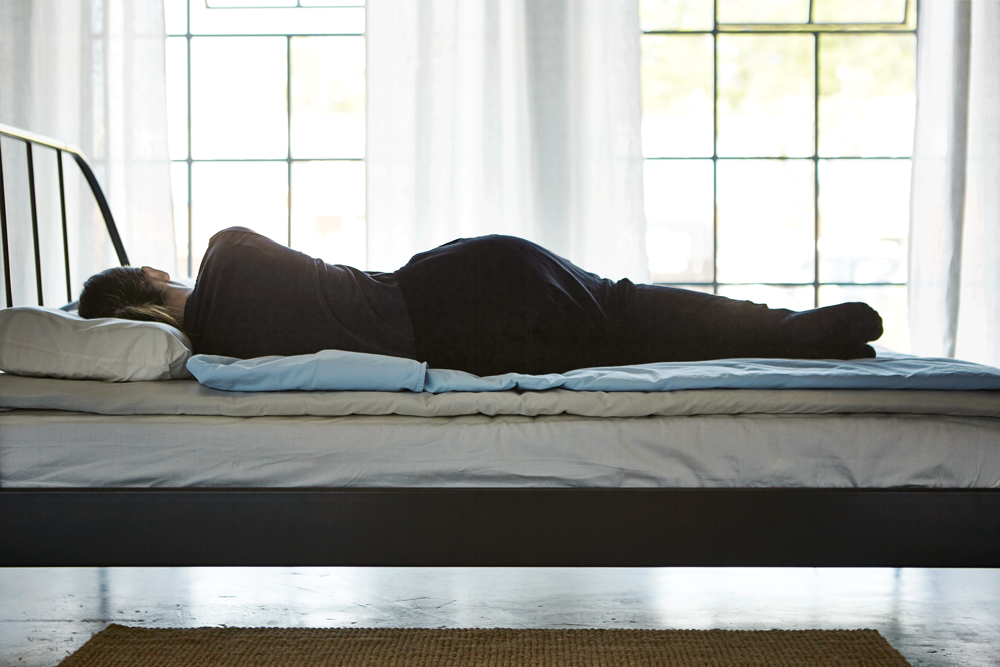 GIF montrant une femme changeant de position sur son lit : sur le côté, sur le dos, sur le ventre.