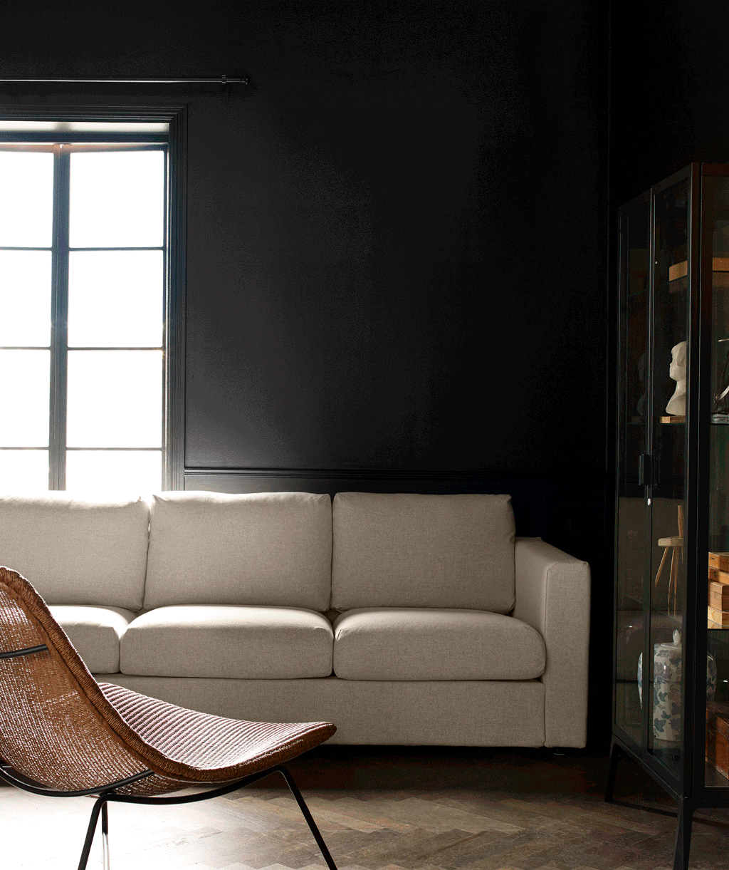 GIF of a cream sofa in a dark green room with various lighting and decor pieces appearing in the space including the RÅDVIKEN armchair