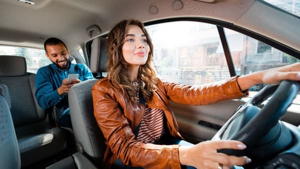 Girl driving guy in car.