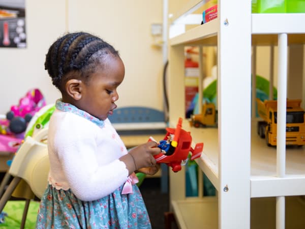 girl playing with a red toy helicopter