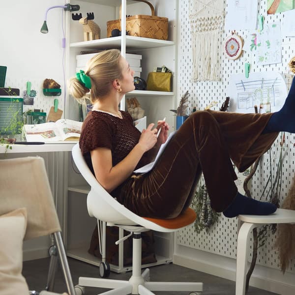 Girl sitting at desk looking at wall