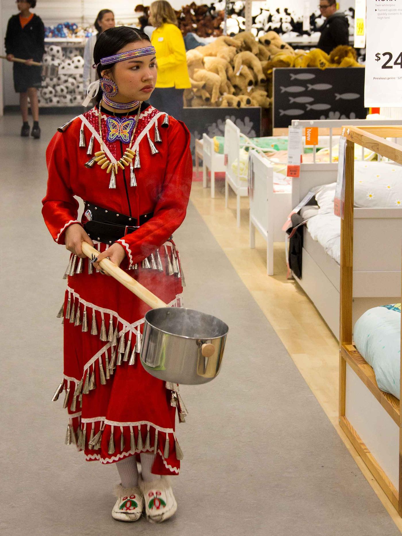 Girl walks in the IKEA store with a smudging pot.