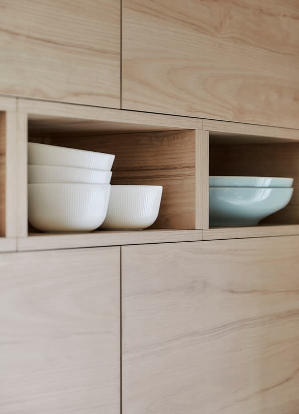 Glad afgewerkte houten IKEA METOD ASKERSUND keukenfronten met essenpatroon waarachter schalen zijn opgeborgen.
