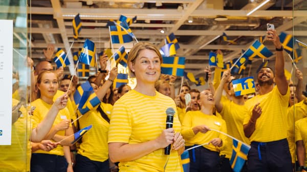Glada medarbetare i gula tröjor inför invigningen av IKEA City i Gallerian.