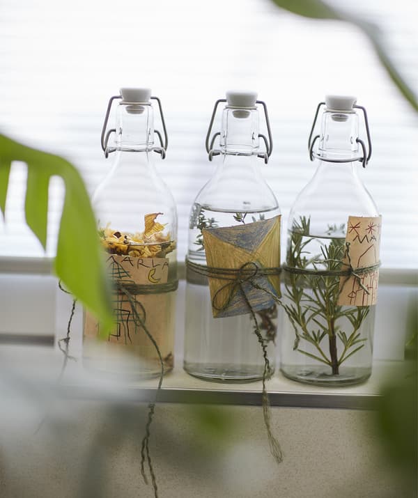 Glass bottles full of liquid and herbs with handmade labels.