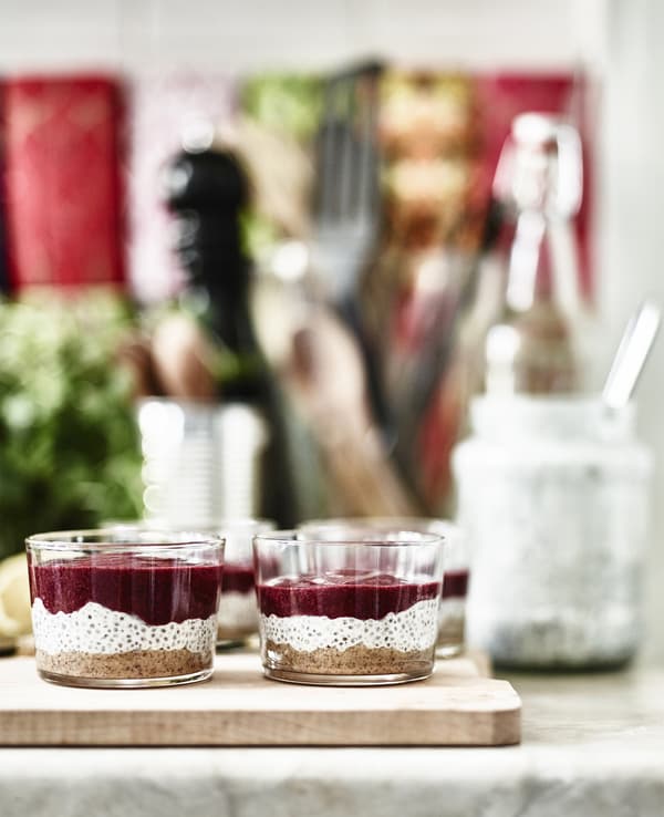 Glass pots of layered chia pudding on a worktop.