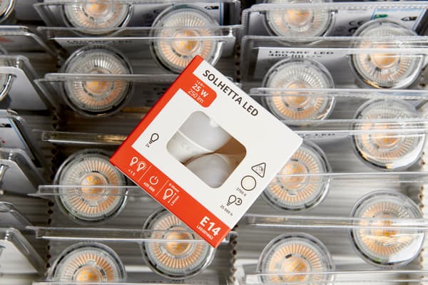 Glödlampa i pappersförpackningar ligger ovan glödlampor plastförpackningar