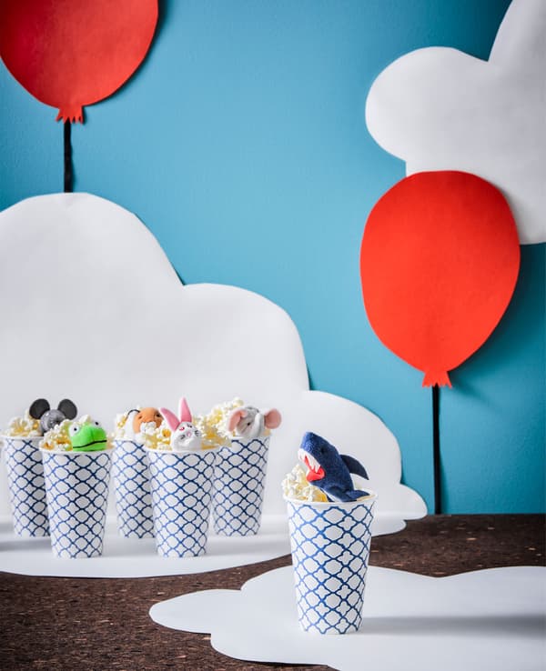 Gobelets en papier remplis de popcorn et décorés d’une marionnette pour doigt.