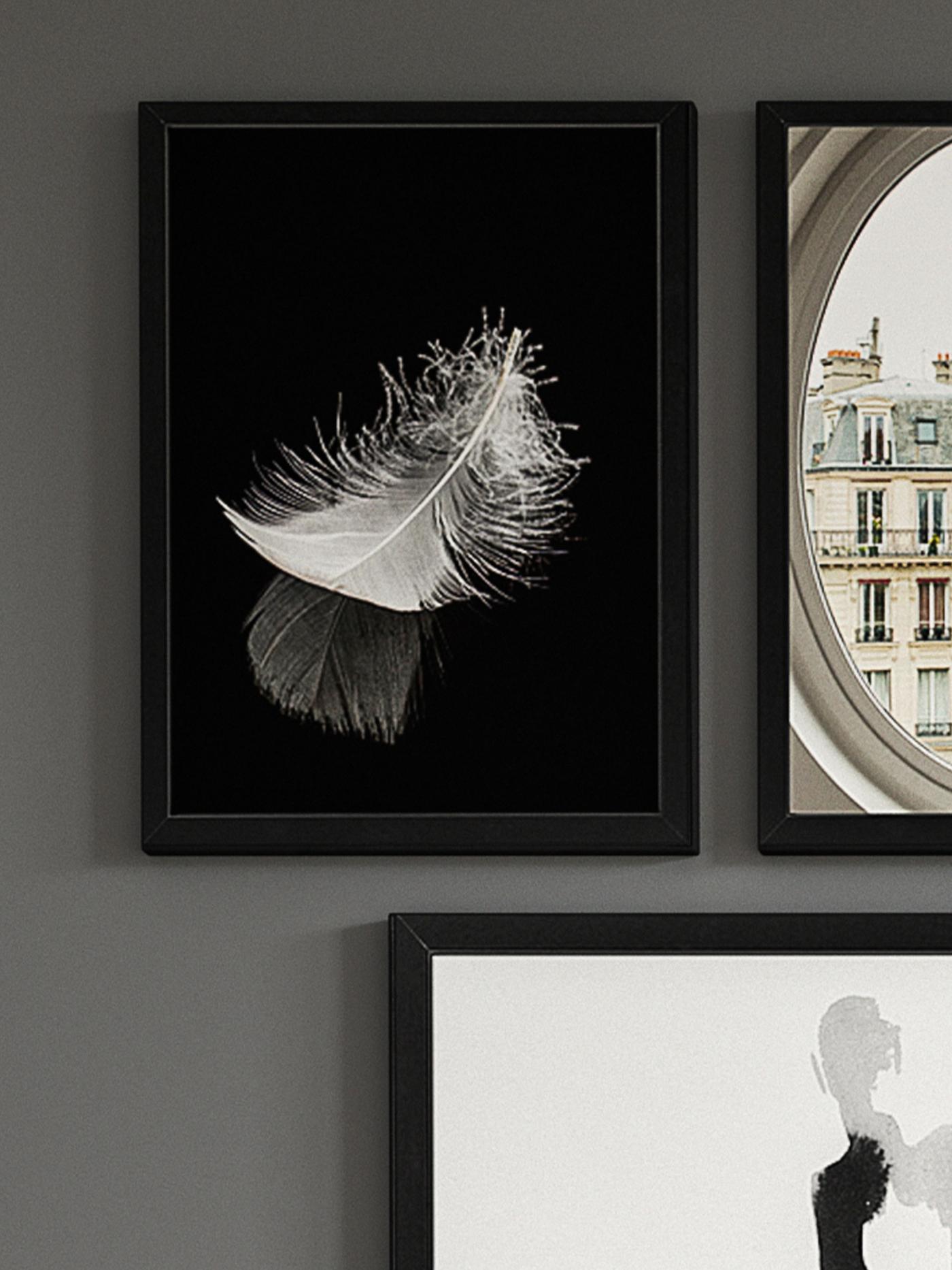 Grå väggar med svartvita tavlor med svarta ramar.