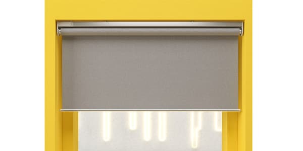 Graues IKEA Rollo in modernem Design, stilvoll angebracht an einem gelb gestrichenen Fensterrahmen – perfekter Sicht- und Sonnenschutz für ein zeitgemäßes Wohnambiente.


