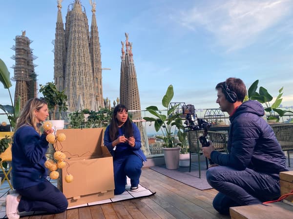 Gravació d’un episodi de Live Shopping d’IKEA amb dues presentadores i un càmera en una terrassa amb vista a la Sagrada Família.