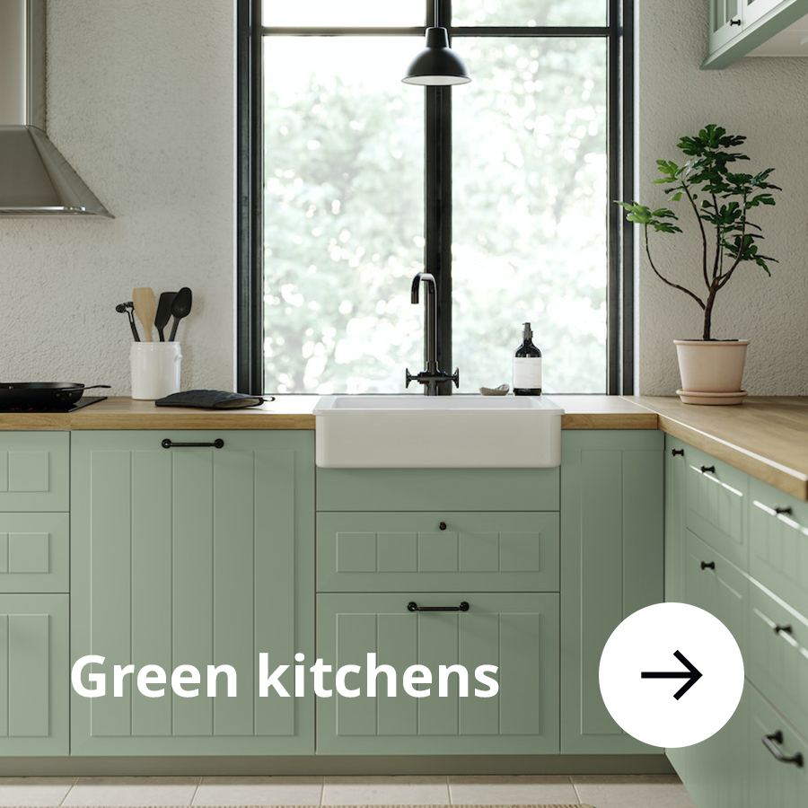 Green kitchen with white sink and black tap.