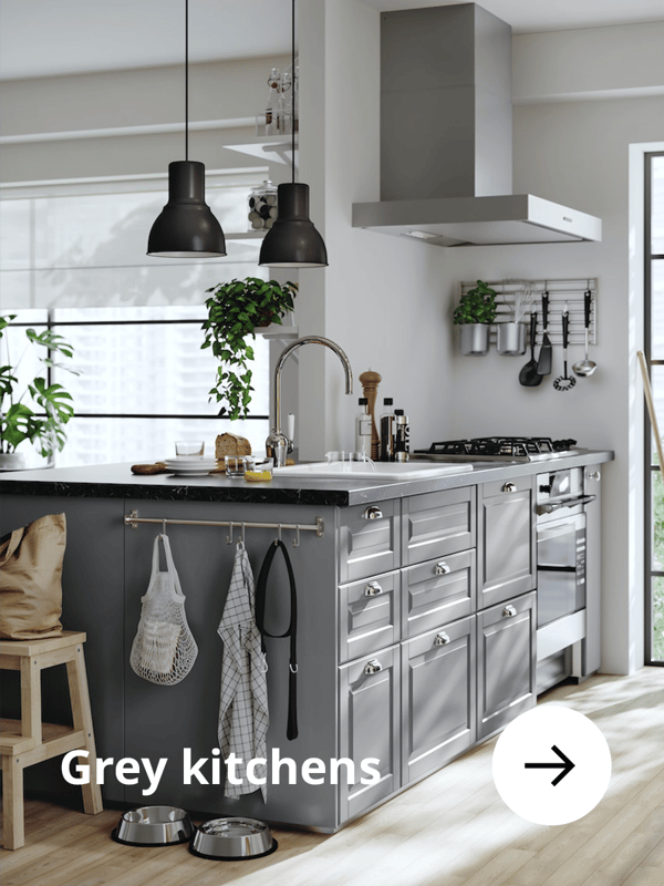 Grey kitchen with black pendants hanging from the ceiling.