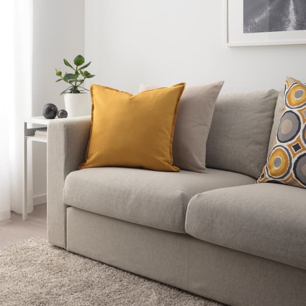 grey sofa with yellow and grey pillows on it 
