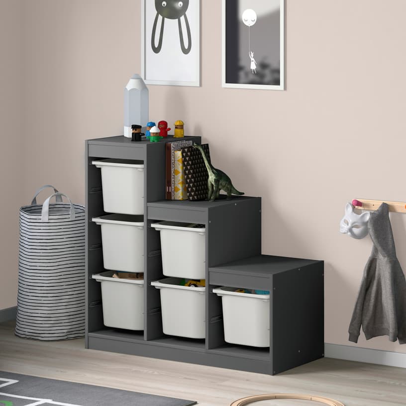 Grey TROFAST storage shelves with storage baskets in child's bedroom next to a laundry basket.