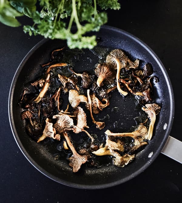 Gros plan de champignons en train de frire dans une poêle.