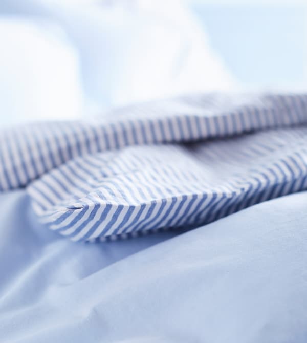 Gros plan de linge de lit en bleu et blanc.